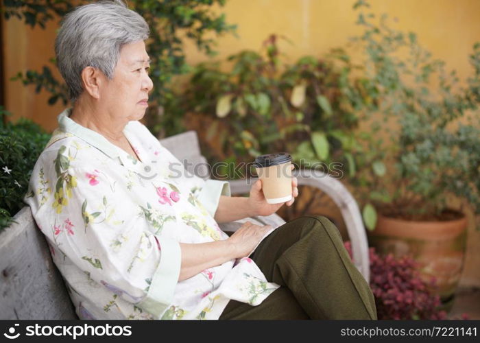 old elderly senior elder woman drinking hot coffee in garden. mature retirement lifestyle