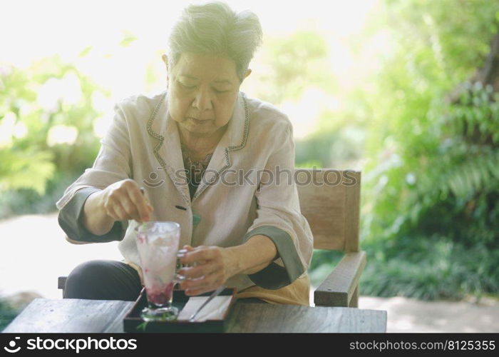 old elderly senior elder woman eating ice cream on terrace. mature retirement lifestyle