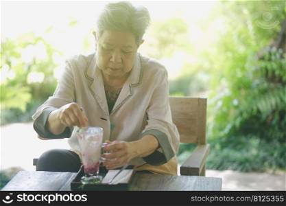 old elderly senior elder woman eating ice cream on terrace. mature retirement lifestyle