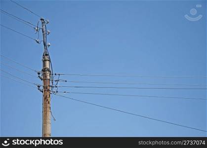 Old electrical wiring. Column on blue sky background