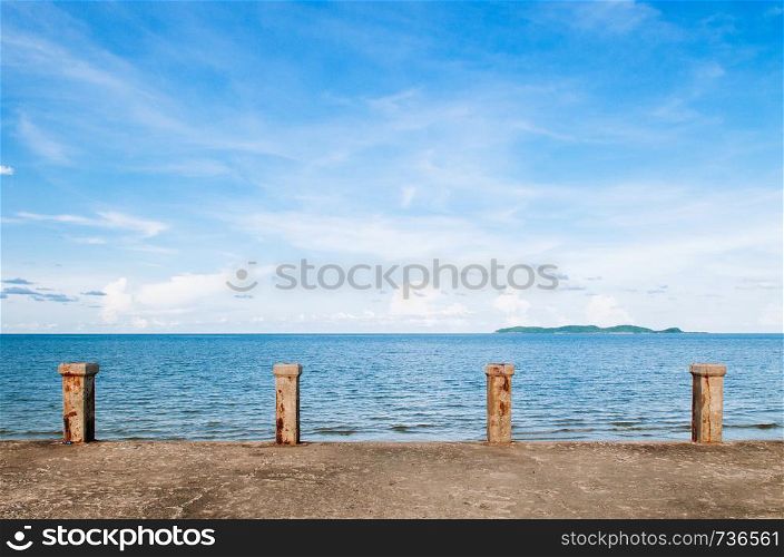 Old empty concrete ship port pier deck tropicl blue summer sky bright sunlight with island view