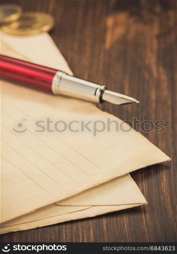 old envelope and ink pen on wood. old envelope and ink pen on wooden background