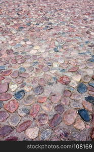 Old European irregular cobblestones of various shapes and sizes in perspective.