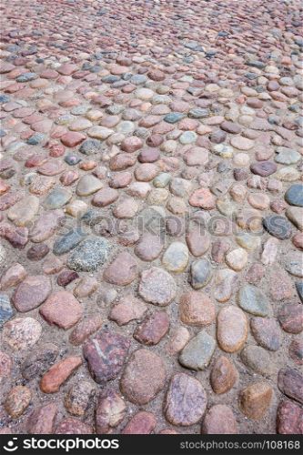 Old European rounded cobblestones of various shapes and sizes in perspective.