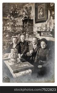 Old family photo parents andchildren. Vintage home interior with Christmas tree
