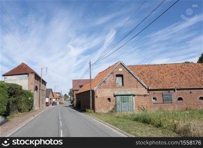 old farm in french village of nord pas de calais under blue sky in summer