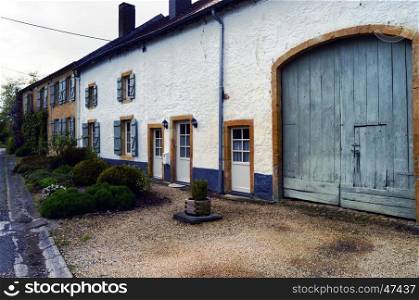 Old farm with a facade in thatch of white color and the flower and plants.