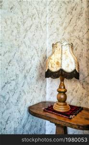 Old fashion table lamp near vintage stylish wallpaper with copy space, antique design space for text. Old fashion table lamp near vintage stylish wallpaper with copy space, antique design