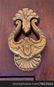 Old fashioned bronze door knocker in Bologna, Italy