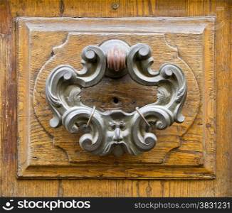 Old fashioned bronze door knocker in Lucca, Tuscany, Italy