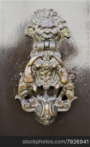 Old fashioned bronze door knocker in Ravenna, Italy