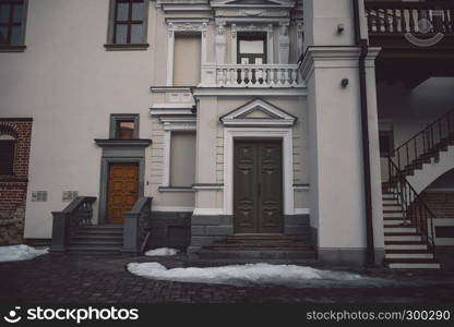 Old fashioned doors in classic style on old building facade background. European designed