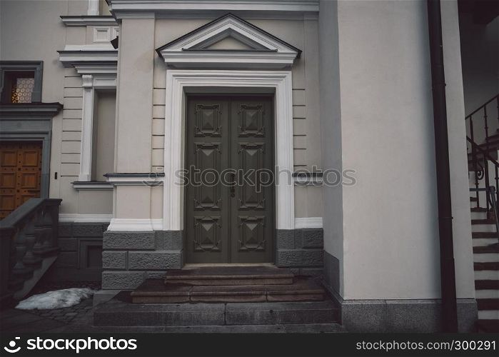 Old fashioned doors in classic style on old building facade background. European designed