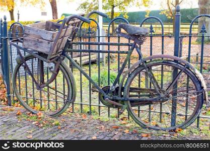 Old fashioned dutch bike against a fence
