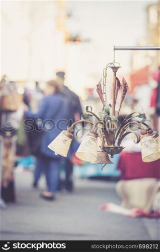 Old fashioned lamp on a flea market, people in the blurry background