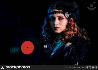 Old-fashioned woman dressed in style of Flappers posing with vinyl record on dark background with neon light. Roaring twenties, retro, party, fashion concept. High quality photo. Old-fashioned woman dressed in style of Flappers posing with vinyl record on dark background with neon light. Roaring twenties, retro, party, fashion concept