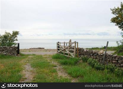 Old fashioned wooden gate by a pathway to the sea at the swedish island Oland