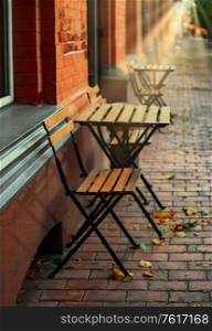Old-fashioned wooden table and chair made of planks outside cafe. Wooden table and chair made of planks outside cafe
