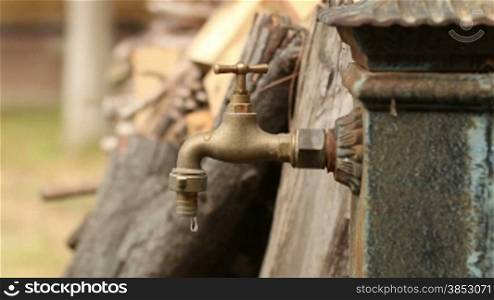 Old faucet dripping. Iron fountain.A man opens and closes the tap.A good clip for ecology, energy saving, sustainability, water waste, domestic economy or saving money ideas.