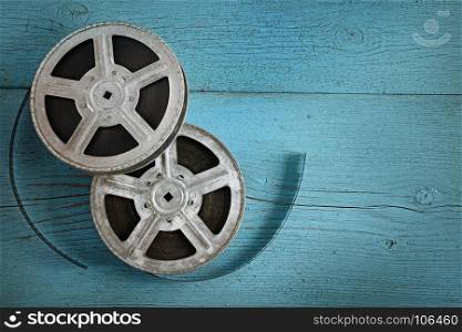 Old film strip on wooden blue background. Top view. Copy space.