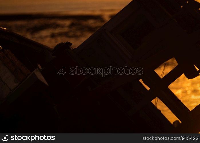 old fishing boat at sunset on the sea beach