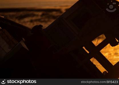 old fishing boat at sunset on the sea beach