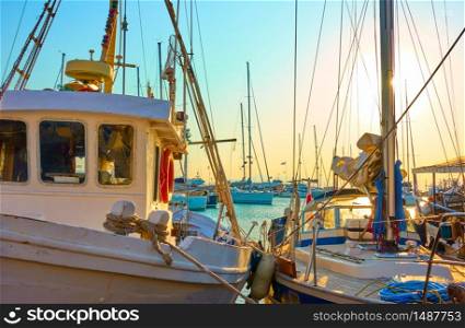 Old fishing boats in the port of Aegina at sunset, Greece