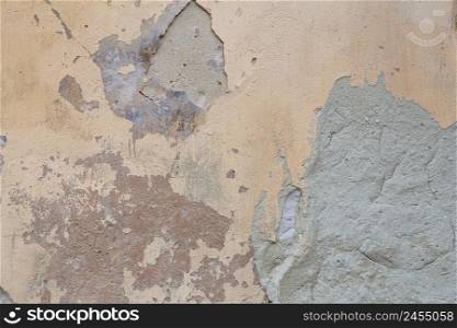 Old flaky wall with destroyed plaster. Renovation of old house. Industrial style design wall background. Grunge cracked concrete wall with old paint. Shabby peeling old background texture