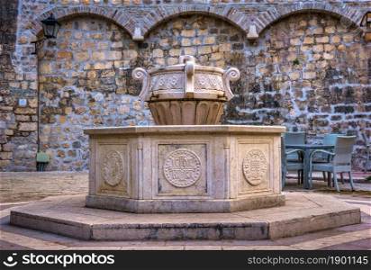 Old fountain near Saint Mary Collegiate church in Kotor. Fountain near church