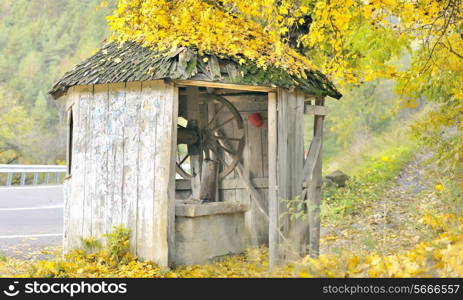 old fountain with shingle roof on autumn time, in Lepsa, Romania