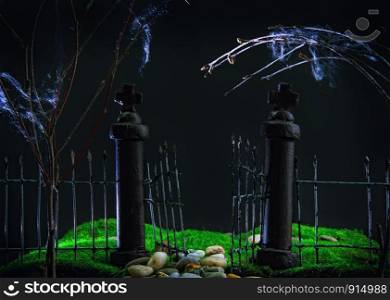 old gloomy rickety iron gate into an abandoned garden with green grass view at night. Toy model. old gate to the garden