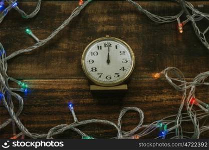 Old golden alarm clock with lights on a wooden background