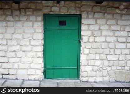 Old green door on the brick wall background. Old green door on the brick wall background.