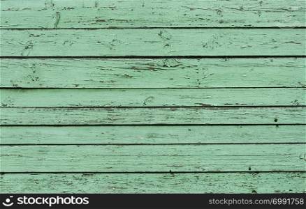 Old green wooden fence with peeling paint