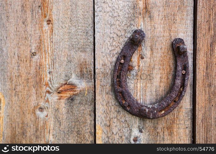 Old grunge horse shoe on wooden background