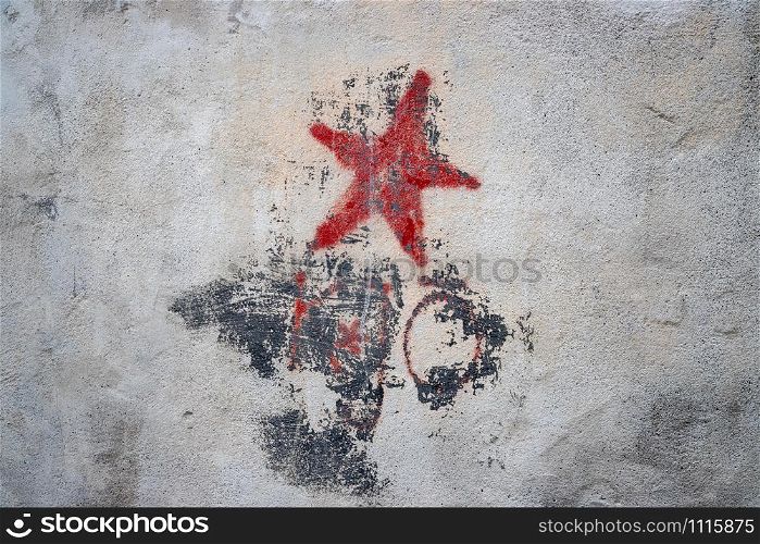 Old grungy communism symbol graffiti on a wall, red color