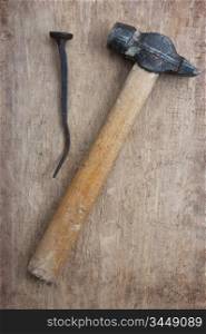 old hammer and a rusty nail on a blackboard