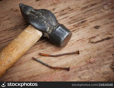 old hammer and a rusty nail on a blackboard