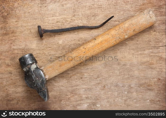 old hammer and a rusty nail on a blackboard