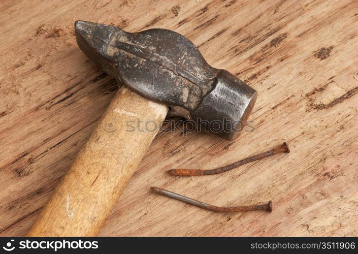 old hammer and a rusty nail on a blackboard