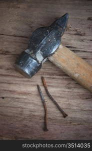 old hammer and a rusty nail on a blackboard