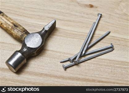 Old hammer and nails on wood background