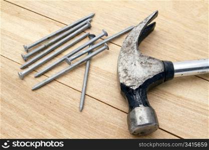 Old hammer and nails on wood background