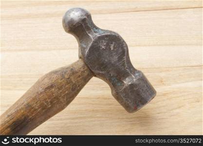 Old hammer closeup on wood background