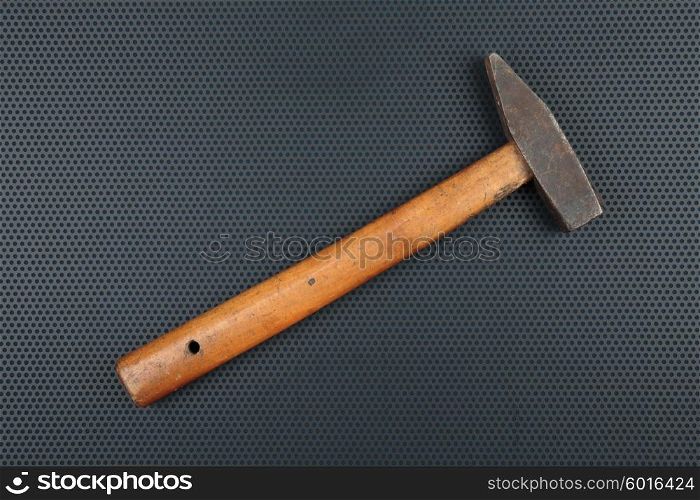 Old hammer on a metallic background