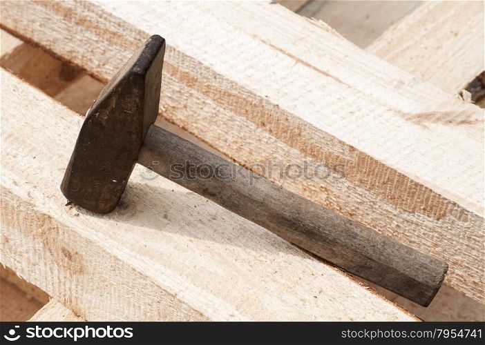 Old hammer on pine wooden lumber beams