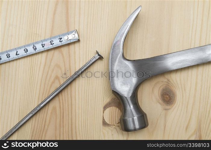 Old hammer , tape measure and nails on wood background