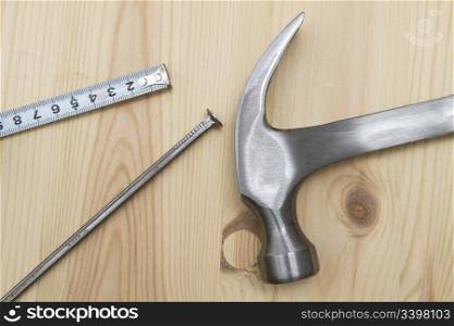 Old hammer , tape measure and nails on wood background