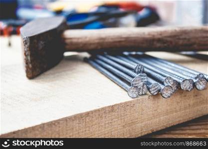Old hammer with nails on the background of boards. Tools for construction work. Close-up.. Old hammer with nails on the background of boards. Tools for construction work.