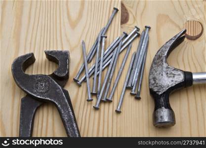 Old hammer,wrench and nails on wood background